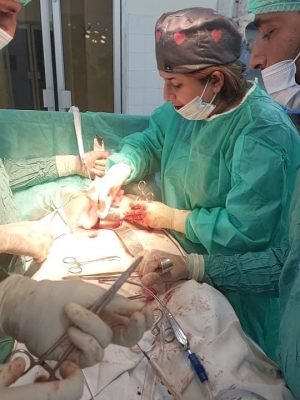 Female surgeon performing a surgical procedure during a late-night shift in an operation theatre.